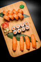 Assorted sushi and rolls in salmon slices, top view