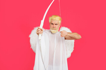 Valentines day celebration. Male cupid in angel wings shoots at target with arrow. God of love....