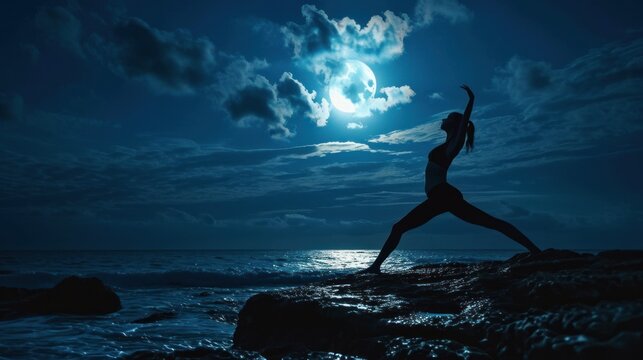  a woman doing a yoga pose on a rock by the ocean at night with a full moon in the sky above her and a body of water in the foreground.