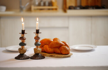 Challah bread, shabbat wine  on the kitchen table. Traditional Jewish Shabbat ritual. Shabbat Shalom.