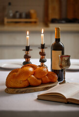 Challah bread covered, shabbat wine and Totah on the kitchen table. Traditional Jewish Shabbat ritual. Shabbat Shalom