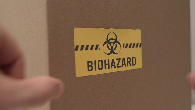 Biohazard Label Being Put on a Box Closeup Dangerous Items