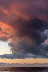 Big fluffy sunset clouds in summer. Orange and purple colors. Golden hour
