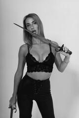 Beautiful woman in lingerie holding two swords in black and white