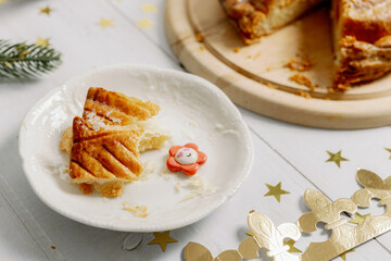One piece of royal galette with a surprise in a saucer on the table.