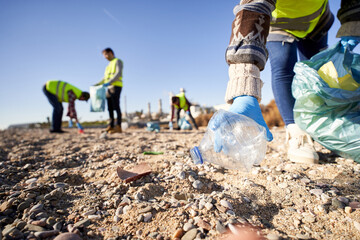 Group of cleanup volunteers cleaning up waste in nature and holding a garbage bag trash. Close up...