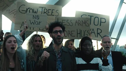 Diverse people protesting against war and violence in the world. Group of activists with anti-war banners at a demonstration for peace and human rights. 