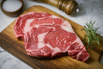 raw ribeye steak beef on white marble background