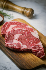 raw ribeye steak beef on white marble background