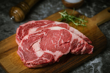 raw ribeye steak meat on black marble background