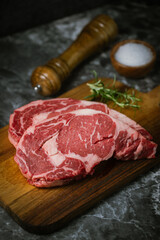 raw ribeye steak meat on black marble background