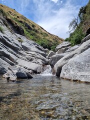 Armonía Acuática: Río Azul Serpenteante entre Piedras y Cascadas