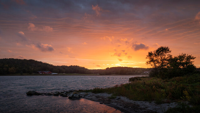 Sunset with colourful clouds in the sky at a lake on the archipelago island of Tj&ouml;rn in the west of Sweden.
