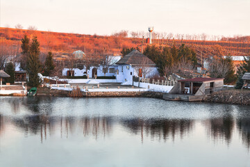 Autumn landscape with lake and old houses in the village