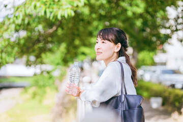 川沿いでリフレッシュする笑顔のビジネスウーマン
