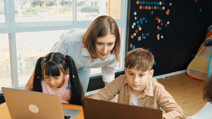 African girl play laptop with diverse friend learning prompt at STEM technology class....