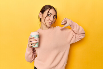 Young caucasian woman holding a takeaway coffee cup feels proud and self confident, example to...