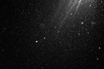 Floating dust particles. White dust  texture on a black background. Snowflakes falling at night from the sky. Great Dust speckle texture background. 