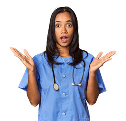 Young Filipina nurse posed in studio surprised and shocked.