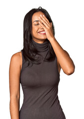 Young Filipina with long black hair in studio laughing happy, carefree, natural emotion.