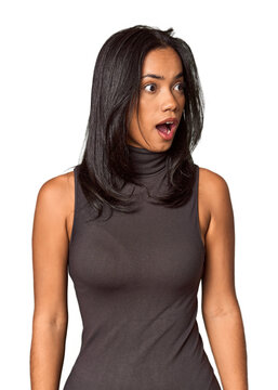 Young Filipina with long black hair in studio being shocked because of something she has seen.