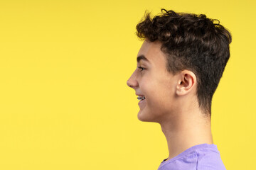 Side view portrait of handsome smiling young boy with dental braces looking away copy space