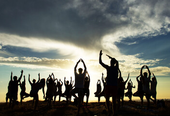 Silhouette of an outdoor yoga class at sunset
