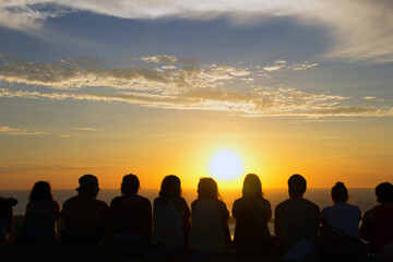 Fototapeta na wymiar Group of people watching a sunset from a mountain 