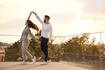 Lovely couple dancing together outdoors at sunset, space for text - Powered by Adobe