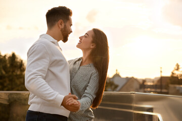 Lovely couple dancing together outdoors at sunset, space for text