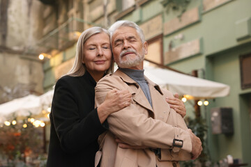Portrait of affectionate senior couple on city street