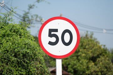 Speed limit sign is on green nature.Maximum speed is 50.