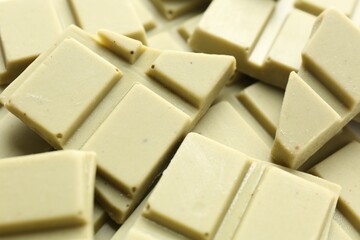 Pieces of tasty matcha chocolate bars as background, closeup