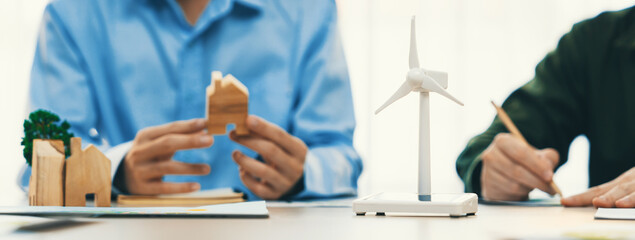 Business people invest in green business plan at meeting room on table with house model and wind...