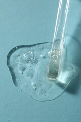 Pipette with cosmetic serum on light blue background, above view