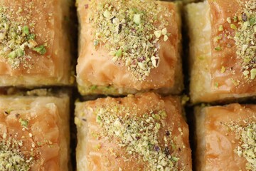 Delicious fresh baklava with chopped nuts as background, top view. Eastern sweets