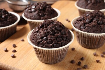 Tasty chocolate muffins on wooden table, closeup