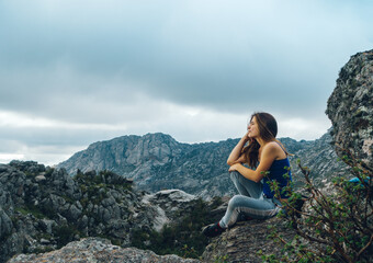 Naklejka na ściany i meble young lady meditate close to the top of a mountain