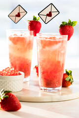 Fresh strawberry lemonade with boba popping pearls against a bright widow.