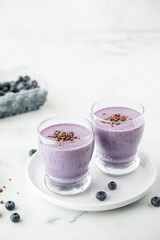 Fresh blueberry smoothies topped with cacao nibs, ready for drinking.