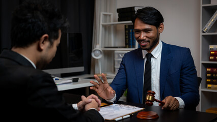 A lawyer is meeting with a new client, a young man in a suit and tie sits at the table. Share legal...
