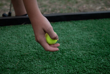 Mano con pelota de golf en acci&oacute;n para apoyarla en c&eacute;sped