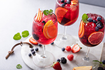 Berry sangria in wine glasses with oranges and a variety of berries