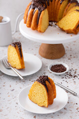 Orange bundt cake topped with chocolate ganache cut into slices