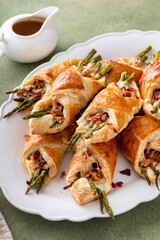Asparagus appetizers wrapped in puff pastry with melted cheese