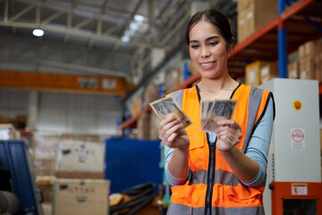 factory worker smiling and counting cash money in the warehouse storage