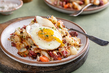 Corned beef hash with potatoes and carrots with fried egg on top