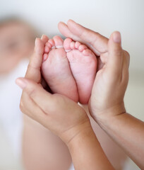 Love, mother and hands with newborn or feet for development, nurture and bonding in nursery of...