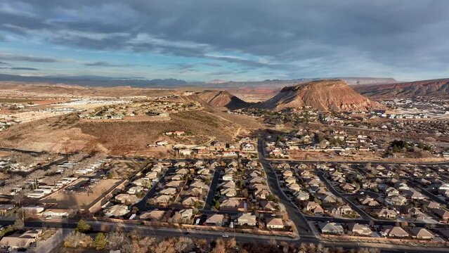 Aerial desert homes Washington Utah afternoon traffic pul. Southwestern desert Utah St George. Fast population growth, mild weather. Mountain desert and river valley. New construction housing economy.