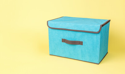 A blue storage box on a yellow background.